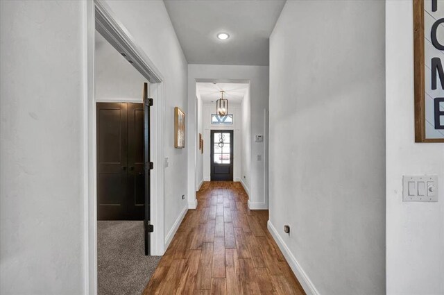2420 NW 179th Ter, Edmond, OK 73012 - hallway featuring an inviting chandelier, baseboards, and hardwood / wood-style floors
