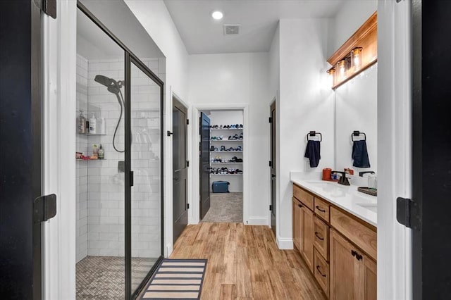 2420 NW 179th Ter, Edmond, OK 73012 - full bath with a walk in closet, a sink, wood finished floors, visible vents, and a stall shower