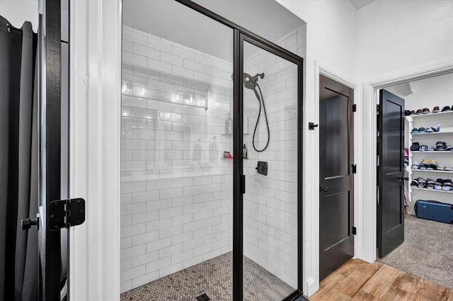 2420 NW 179th Ter, Edmond, OK 73012 - full bath featuring wood finished floors, a walk in closet, and a stall shower