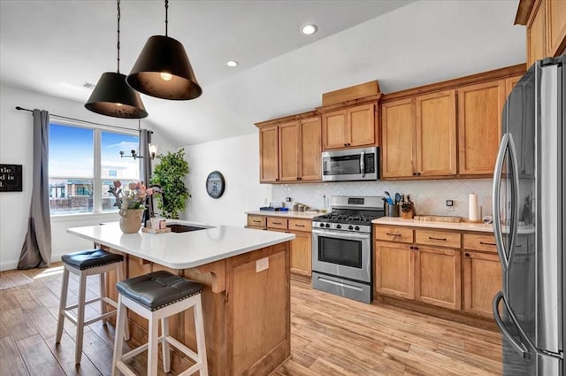 2420 NW 179th Ter, Edmond, OK 73012 - kitchen featuring light countertops, stainless steel appliances, decorative backsplash, light wood-type flooring, and vaulted ceiling