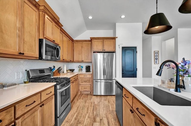 2420 NW 179th Ter, Edmond, OK 73012 - kitchen with brown cabinetry, backsplash, a sink, stainless steel appliances, and light wood-style flooring