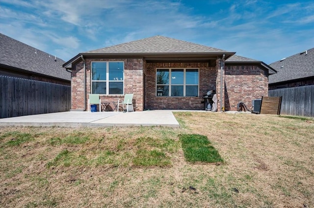 2420 NW 179th Ter, Edmond, OK 73012 - back of property featuring a fenced backyard, roof with shingles, brick siding, a patio area, and a yard
