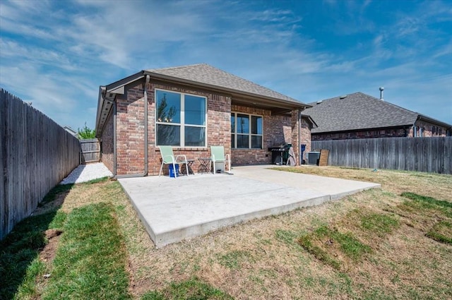 2420 NW 179th Ter, Edmond, OK 73012 - back of property featuring a lawn, brick siding, and a patio
