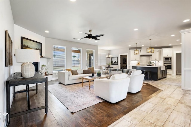 13120 Knight Island Dr, Oklahoma City, OK 73142 - living room with light wood finished floors, recessed lighting, and ceiling fan with notable chandelier