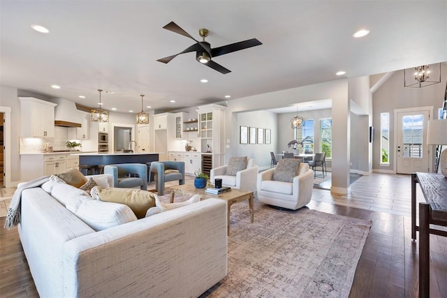13120 Knight Island Dr, Oklahoma City, OK 73142 - living room with wood finished floors, ceiling fan with notable chandelier, baseboards, and recessed lighting