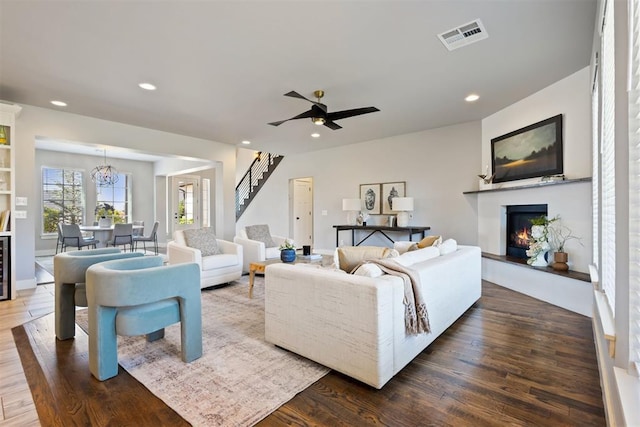 13120 Knight Island Dr, Oklahoma City, OK 73142 - living room featuring a lit fireplace, recessed lighting, stairs, visible vents, and wood finished floors