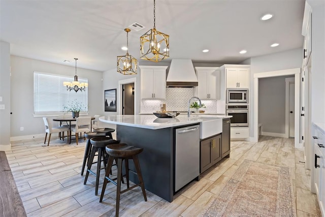 13120 Knight Island Dr, Oklahoma City, OK 73142 - kitchen with custom exhaust hood, a chandelier, white cabinets, decorative backsplash, and stainless steel appliances