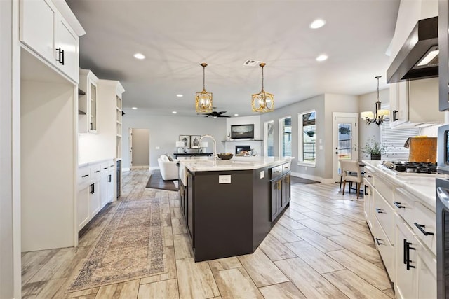 13120 Knight Island Dr, Oklahoma City, OK 73142 - kitchen featuring a chandelier, open floor plan, stainless steel gas cooktop, and wall chimney range hood