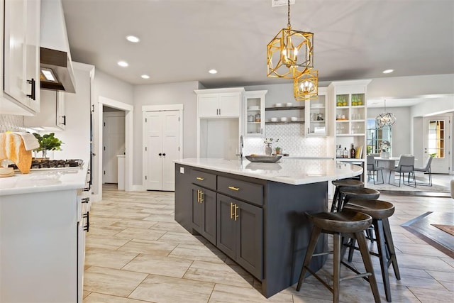13120 Knight Island Dr, Oklahoma City, OK 73142 - kitchen featuring white cabinetry, light countertops, hanging light fixtures, a breakfast bar area, and a notable chandelier