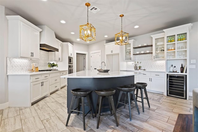 13120 Knight Island Dr, Oklahoma City, OK 73142 - kitchen featuring custom exhaust hood, a chandelier, white cabinets, visible vents, and beverage cooler