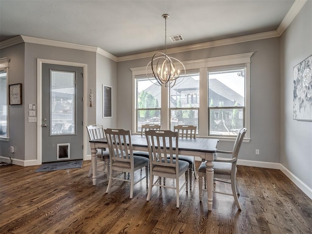 dining space with an inviting chandelier, dark wood finished floors, baseboards, ornamental molding, and visible vents