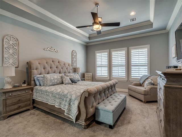 bedroom featuring a tray ceiling, visible vents, light colored carpet, and ornamental molding
