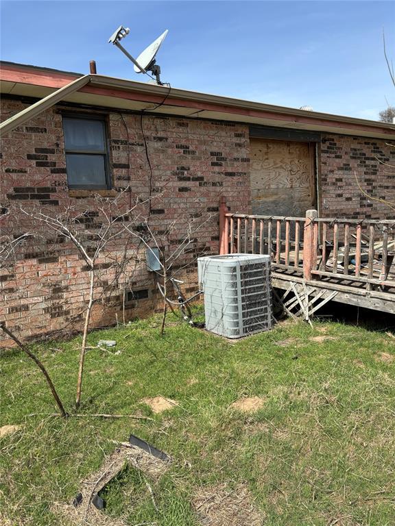 107068 N 3620th Rd, Paden, OK 74860 - view of home's exterior with a wooden deck, a lawn, brick siding, and central AC unit