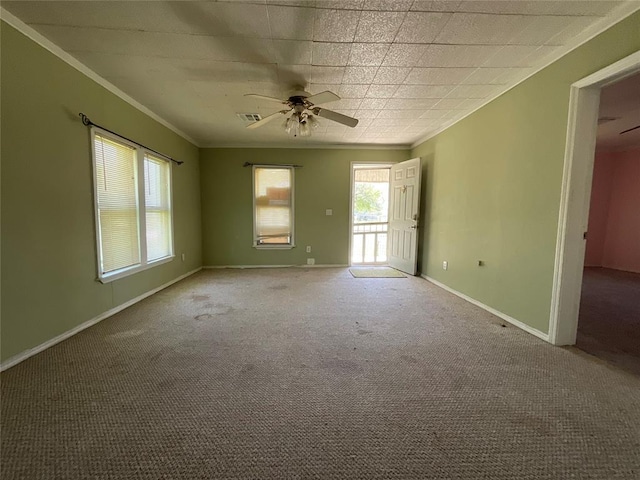 empty room featuring visible vents, baseboards, ornamental molding, ceiling fan, and carpet