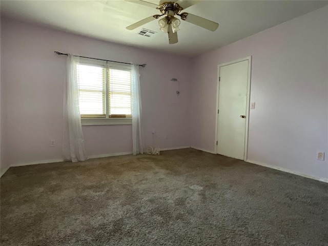 spare room featuring carpet flooring, visible vents, and ceiling fan