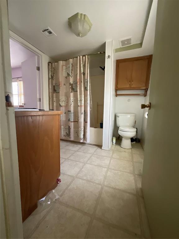 bathroom featuring tile patterned floors, visible vents, and toilet