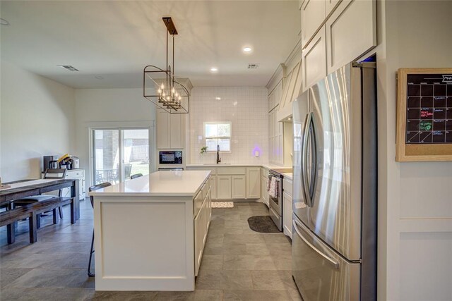 308 W Kerby Ave, Washington, OK 73080 - kitchen with visible vents, a sink, light countertops, appliances with stainless steel finishes, and a kitchen island