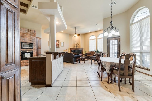 19605 Talavera Ln, Edmond, OK 73012 - dining space featuring a fireplace, visible vents, and a wealth of natural light