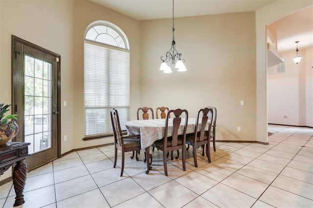19605 Talavera Ln, Edmond, OK 73012 - dining area featuring an inviting chandelier, baseboards, arched walkways, and light tile patterned flooring