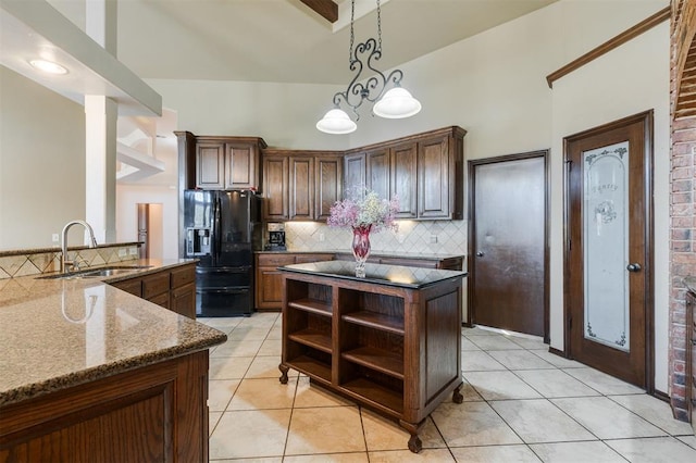 19605 Talavera Ln, Edmond, OK 73012 - kitchen with light tile patterned floors, black fridge, open shelves, a kitchen island, and a sink