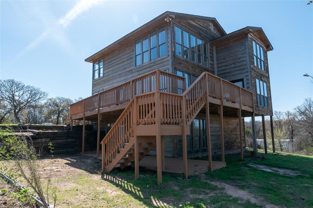 10701 NE 132nd Ave, Newalla, OK 74857 - rear view of property with stairway, a wooden deck, and a lawn