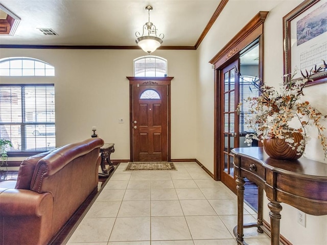 foyer featuring healthy amount of natural light, crown molding, light tile patterned flooring, and baseboards
