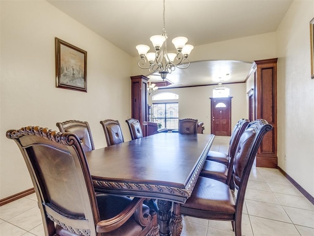 dining area with a chandelier, light tile patterned floors, and baseboards