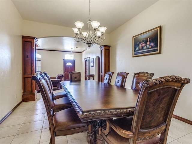 dining room with arched walkways, a chandelier, baseboards, and light tile patterned floors