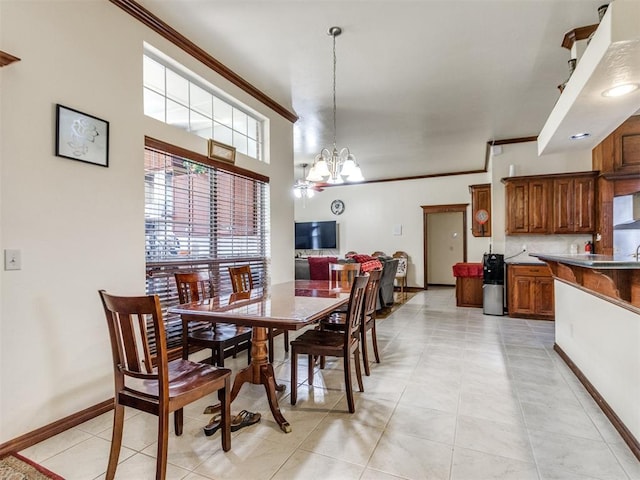 dining area featuring a chandelier, crown molding, baseboards, and light tile patterned floors
