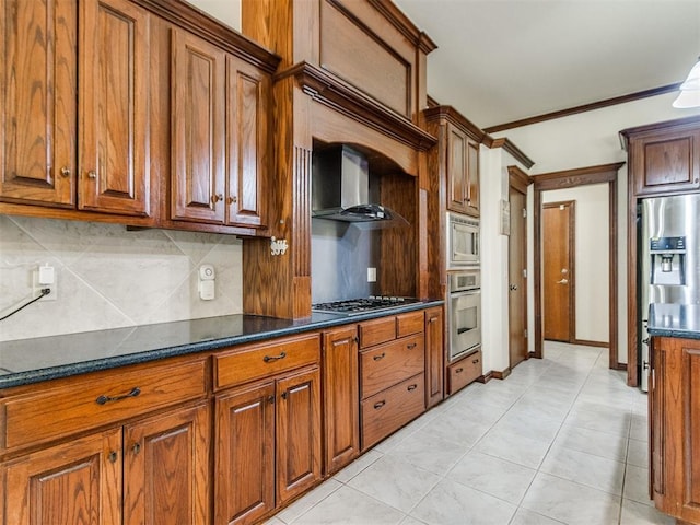 kitchen with stainless steel appliances, wall chimney range hood, decorative backsplash, brown cabinetry, and ornamental molding
