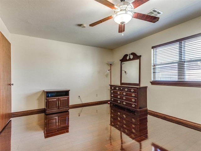 sitting room with baseboards, a ceiling fan, and wood finished floors