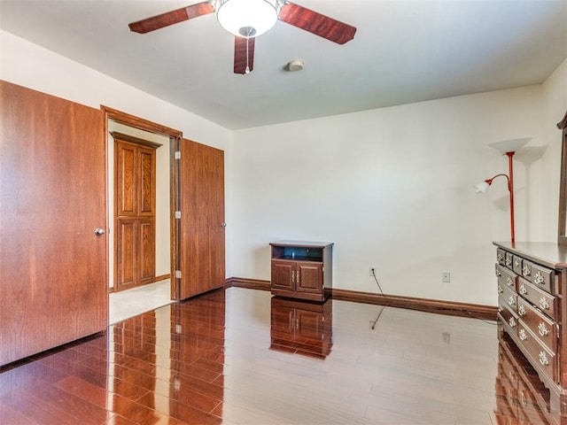 unfurnished room featuring ceiling fan, baseboards, and wood finished floors