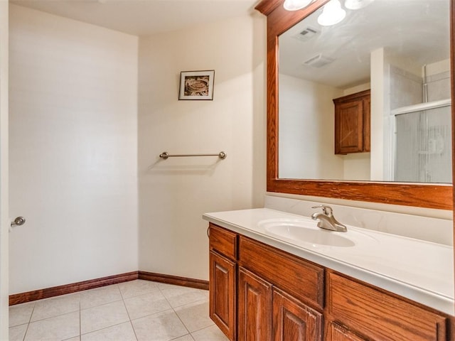 bathroom with baseboards, vanity, tile patterned floors, and an enclosed shower
