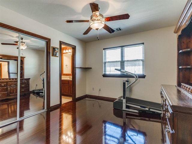 workout room with a ceiling fan, wood finished floors, and baseboards