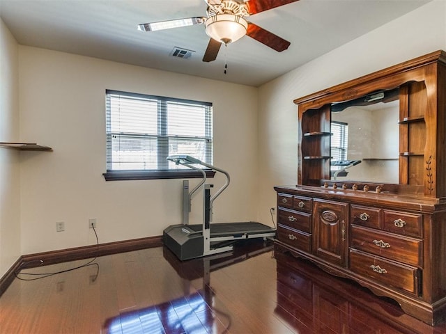 exercise room with healthy amount of natural light, dark wood-type flooring, ceiling fan, and baseboards