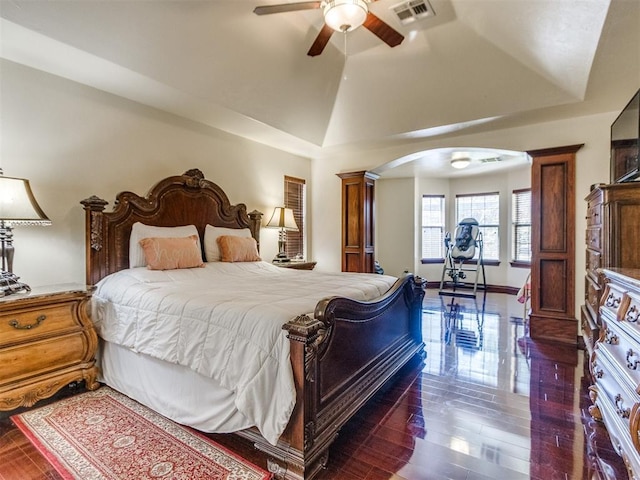 bedroom with arched walkways, wood finished floors, ceiling fan, vaulted ceiling, and baseboards