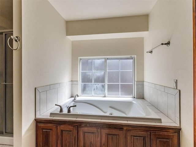 bathroom featuring a stall shower and a tub with jets