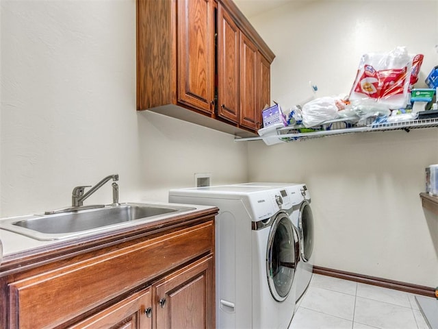 clothes washing area with washer and clothes dryer, cabinet space, and light tile patterned floors