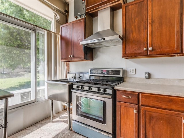 kitchen with wall chimney exhaust hood, stainless steel gas range oven, plenty of natural light, and light countertops