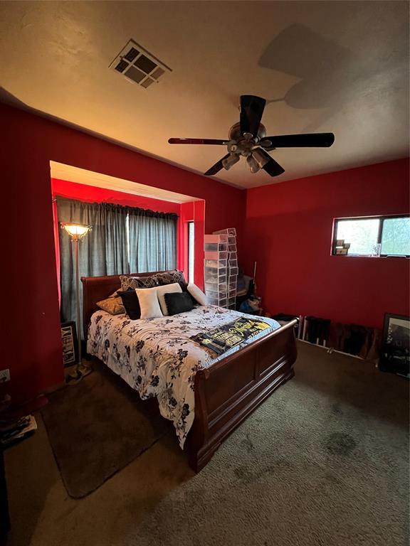 carpeted bedroom with visible vents and ceiling fan