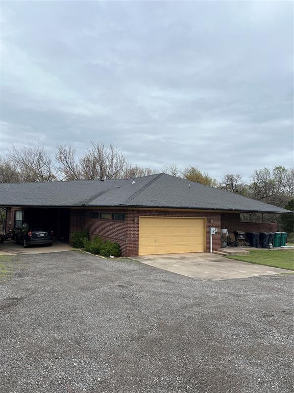 ranch-style house featuring brick siding, driveway, and an attached garage
