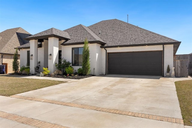 8416 NW 130th St, Oklahoma City, OK 73142 - french provincial home featuring a front yard, a shingled roof, a garage, concrete driveway, and brick siding
