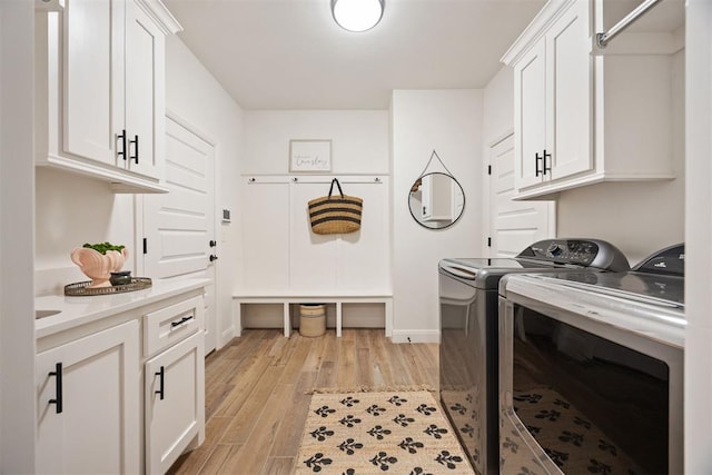 8416 NW 130th St, Oklahoma City, OK 73142 - washroom featuring cabinet space, washer and clothes dryer, light wood-style floors, and baseboards