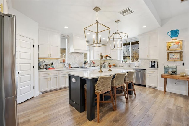 8416 NW 130th St, Oklahoma City, OK 73142 - kitchen with a notable chandelier, white cabinetry, visible vents, and stainless steel appliances