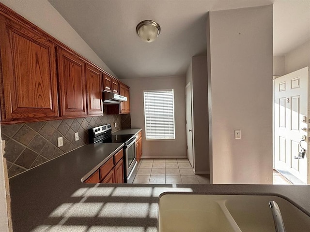 kitchen featuring stainless steel electric range oven, dark countertops, light tile patterned floors, tasteful backsplash, and under cabinet range hood