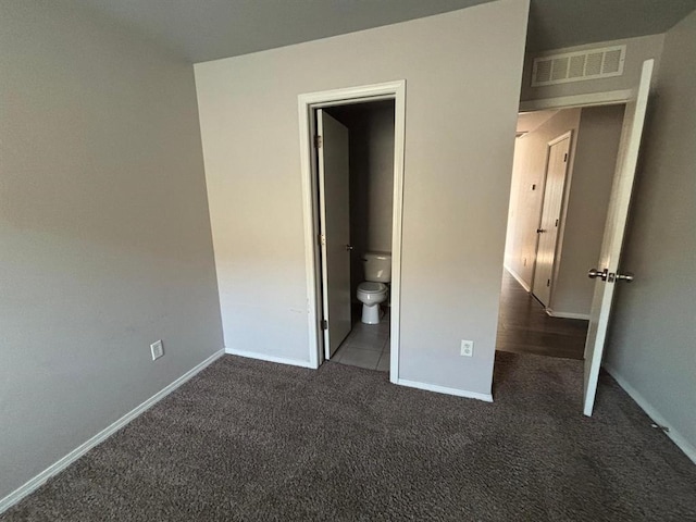unfurnished bedroom featuring visible vents, carpet, ensuite bathroom, and baseboards