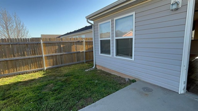 view of home's exterior with a lawn, fence, and a patio