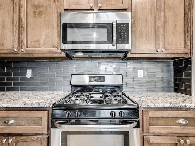 207 Lyla Glen St, Washington, OK 73093 - kitchen with stainless steel appliances, tasteful backsplash, and light stone counters