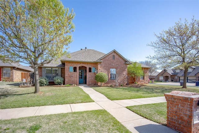 4621 NW 157th Ter, Edmond, OK 73013 - view of front of property featuring brick siding, a front yard, and a shingled roof