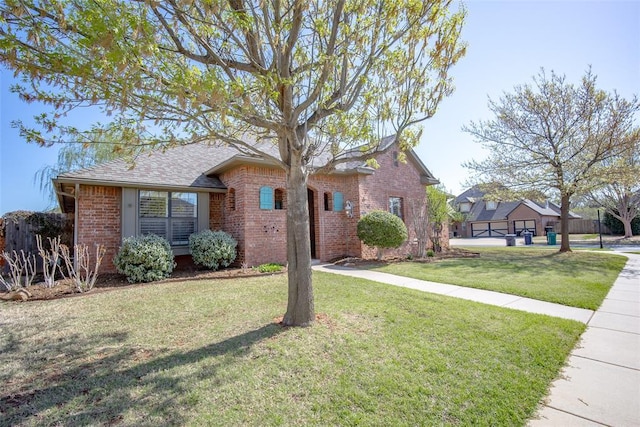 4621 NW 157th Ter, Edmond, OK 73013 - view of front of house with brick siding, a front yard, and a shingled roof